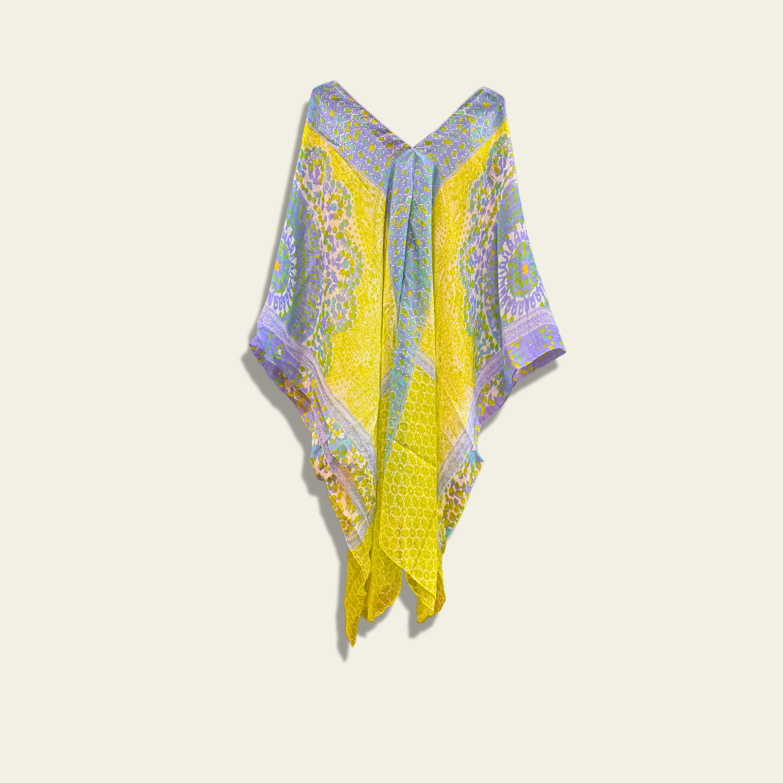 This lightweight chiffon poncho drapes beautifully, showcasing a vibrant blend of green and blue with an abstract print.